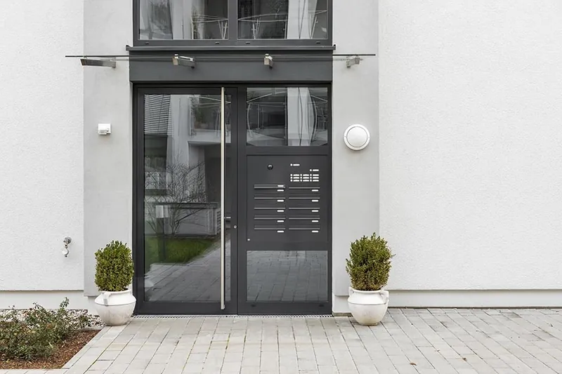 In die Hauswand eingebaute Briefkastenanlage neben einem Hauseingang