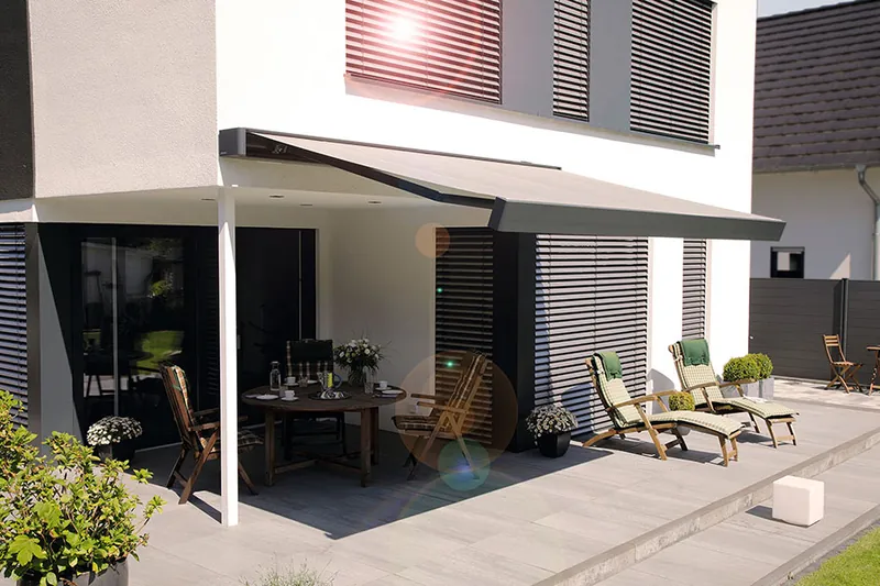 Beschattete Terrasse mit Sitzgruppe an einem Wohnhaus